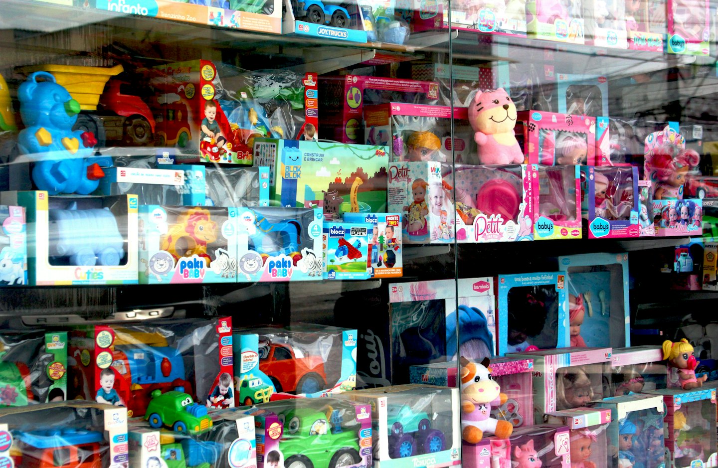 Toy store window display with stuffed animals and building blocks.