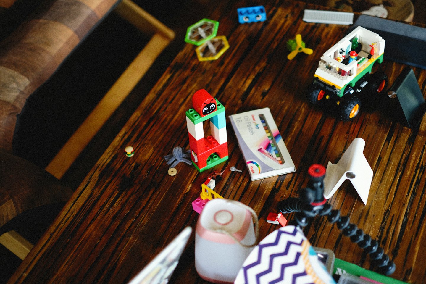 Lego blocks and art supplies scattered on a wooden table.